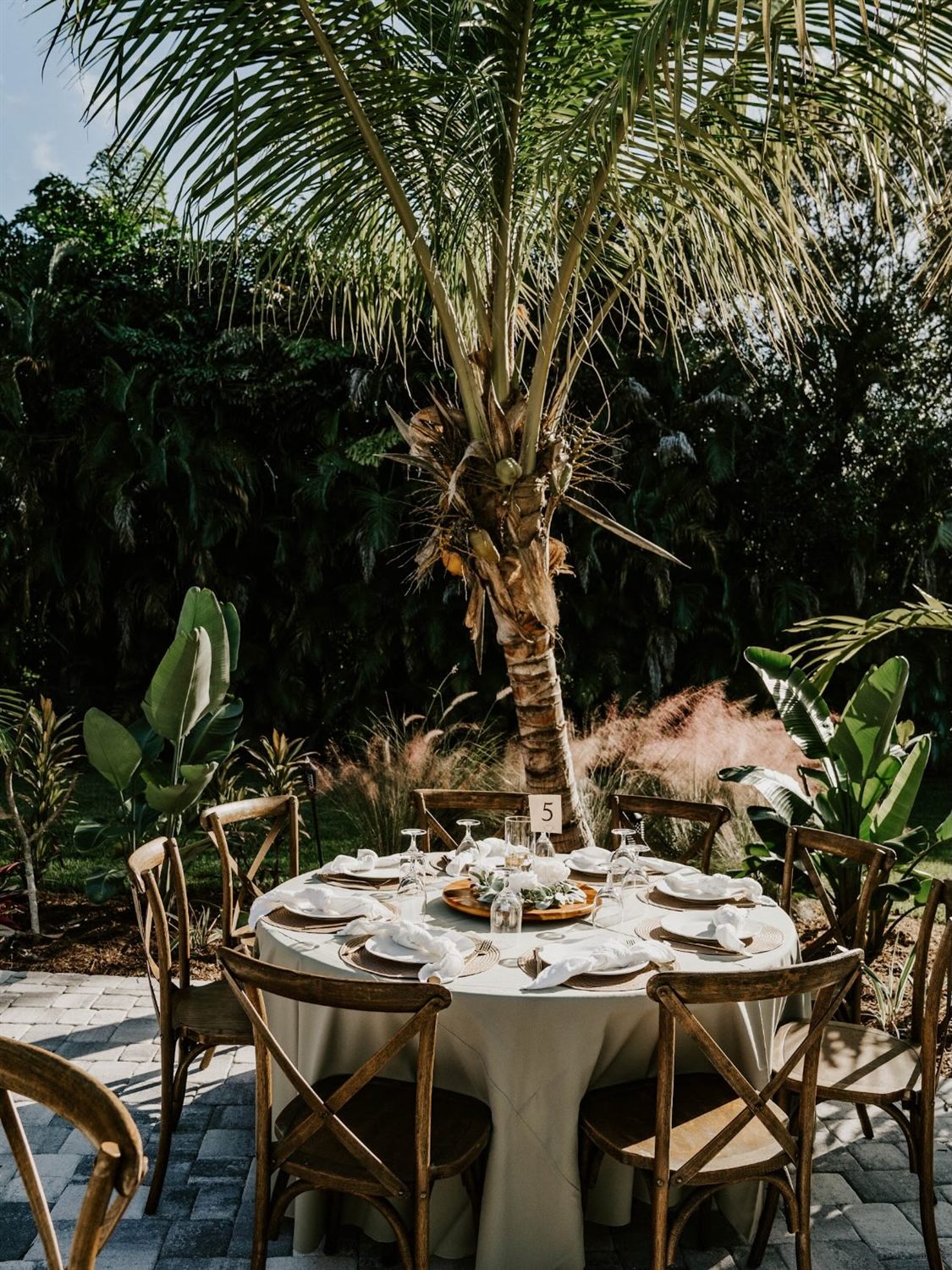 An elegant outdoor wedding reception table styled with florals and candlelight