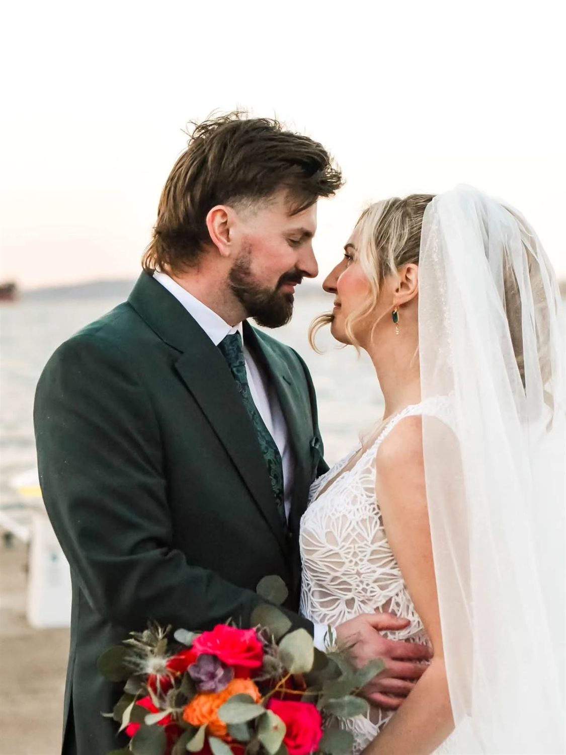 A couple shares a warm kiss on their wedding day