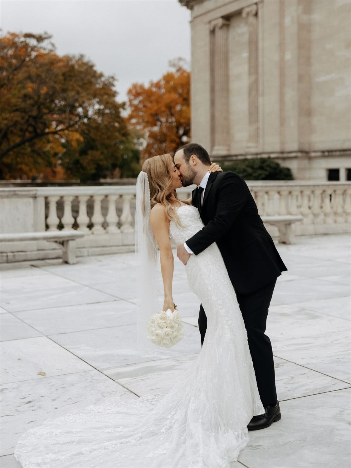 A couple shares a tender moment, captured in soft black and white
