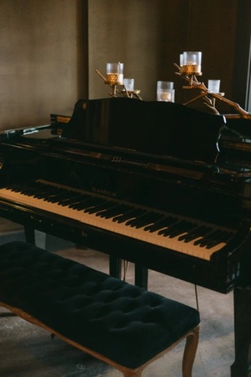 A black grand piano styled with an antler candelabra at an elegant wedding reception