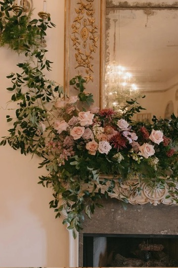 A lush mantel arrangement of blush garden roses and dahlias designed by Made With Love Events