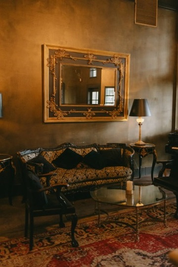 A vintage wedding lounge with a gilded mirror, antique sofa and Persian rug
