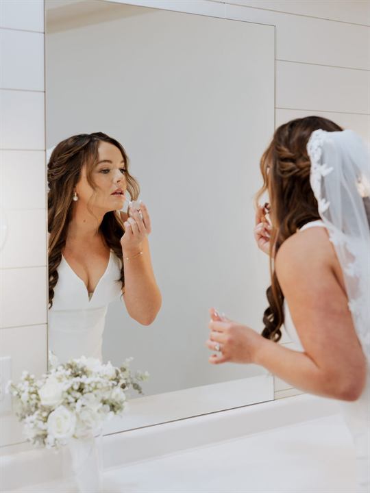 A bride adds final touches in the mirror