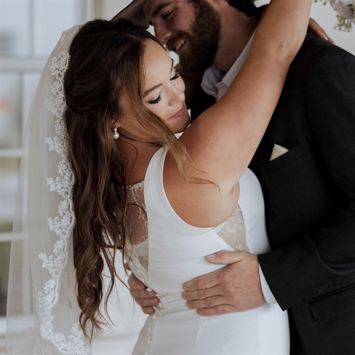 Bride and groom in a soft light-filled embrace